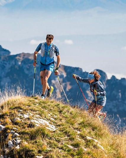 Freunde in Outdoor-Bekleidung rösten Marshmallows an einer Feuerschale in den Bergen