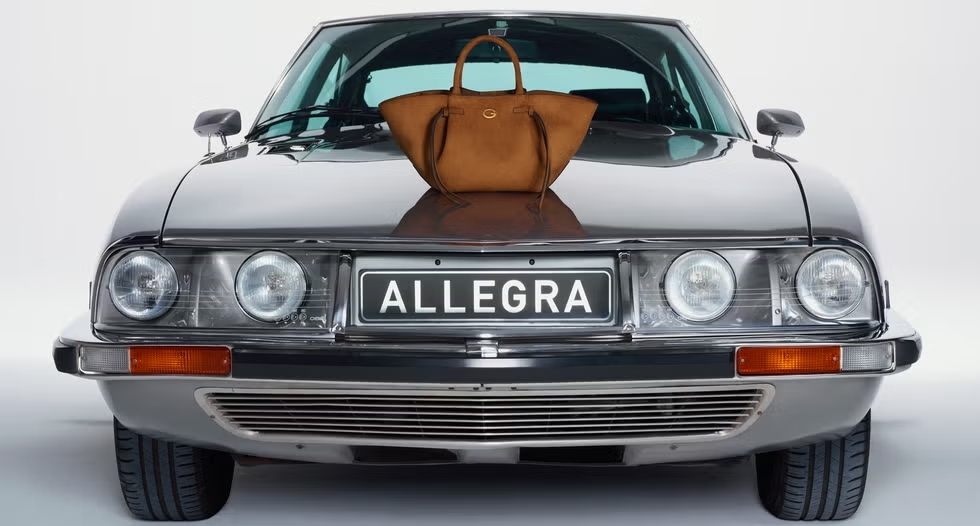 GUESS-Wildlederhandtasche auf der Motorhaube eines Oldtimers mit dem Kennzeichen ALLEGRA